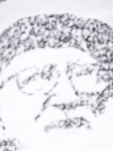 Fresque de JonOne en hommage à l'abbé Pierre, portrait fait de calligraphie noire sur fond blanc
